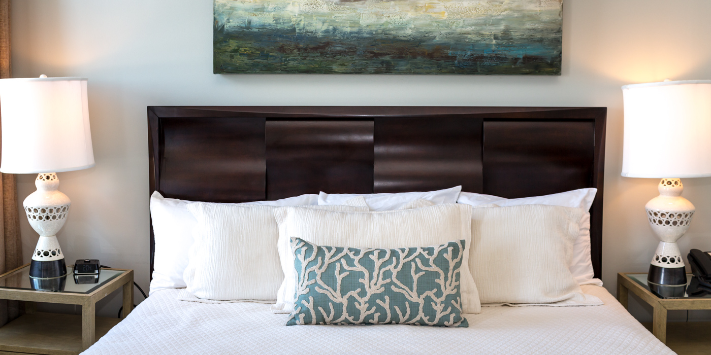 a bed with white pillows and blue and white pillows